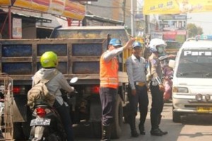 Nampak petugas kepolisian sedang mengatur lalin di kawasan pasar Ciputat yang macet parah.